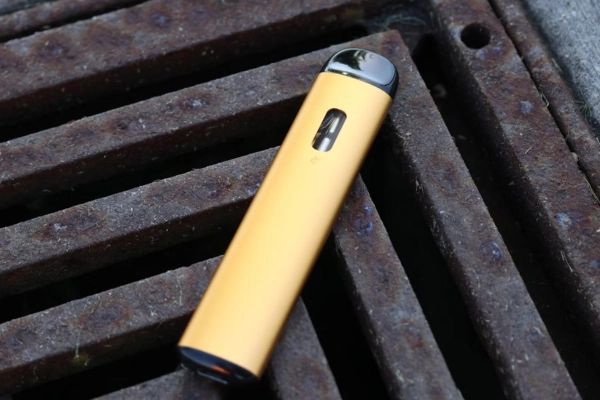 A big disposable vape device lying on a metal grate