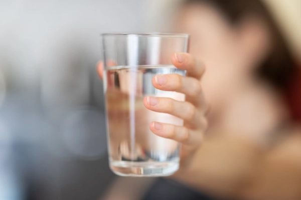 A hand holding a glass of water